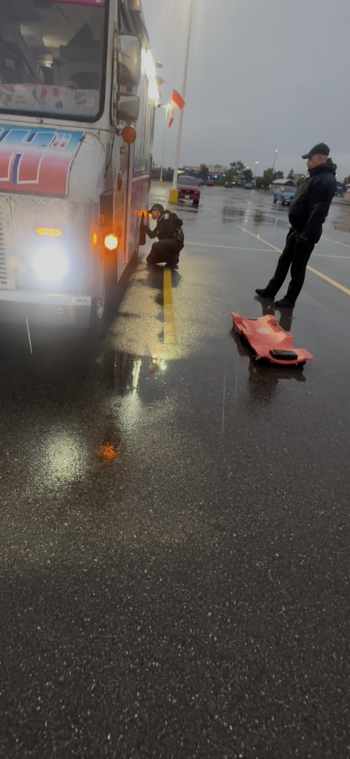 Police officers beside a truck in a parking lot